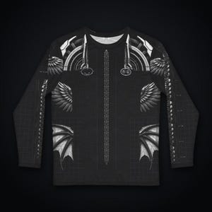 Pu&ograve; includere: Una maglia nera a maniche lunghe con una stampa grafica bianca di elementi meccanici e alati. Il design presenta motivi alari simmetrici, schemi geometrici circolari e un dettaglio centrale verticale simile a una colonna.