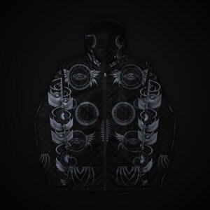 May include: A black zip-up hooded jacket featuring a repeating pattern of grey circular motifs, winged eyes, and geometric lines. The garment has a full-length front zipper, long sleeves, and a hood, all decorated with intricate, symmetrical graphic designs.