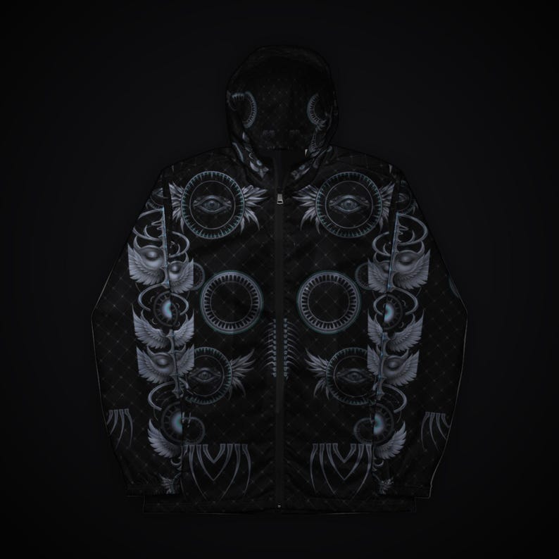 May include: A black zip-up hooded jacket featuring a repeating pattern of grey circular motifs, winged eyes, and geometric lines. The garment has a full-length front zipper, long sleeves, and a hood, all decorated with intricate, symmetrical graphic designs.