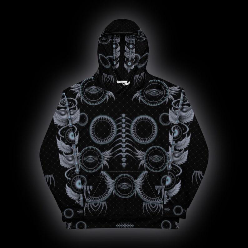 Puede incluir: Una sudadera con capucha negra con un estampado integral de motivos oculares circulares grises, s&iacute;mbolos alados y patrones de columna vertebral. El dise&ntilde;o incluye detalles geom&eacute;tricos complejos y una textura de puntos.