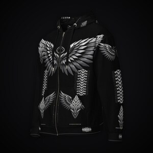 May include: A black zip-up hoodie featuring a large white and gray graphic of feathered wings across the chest and smaller wing motifs on the lower front and sleeves. The design includes vertical spinal-like patterns and a hood with drawstrings.