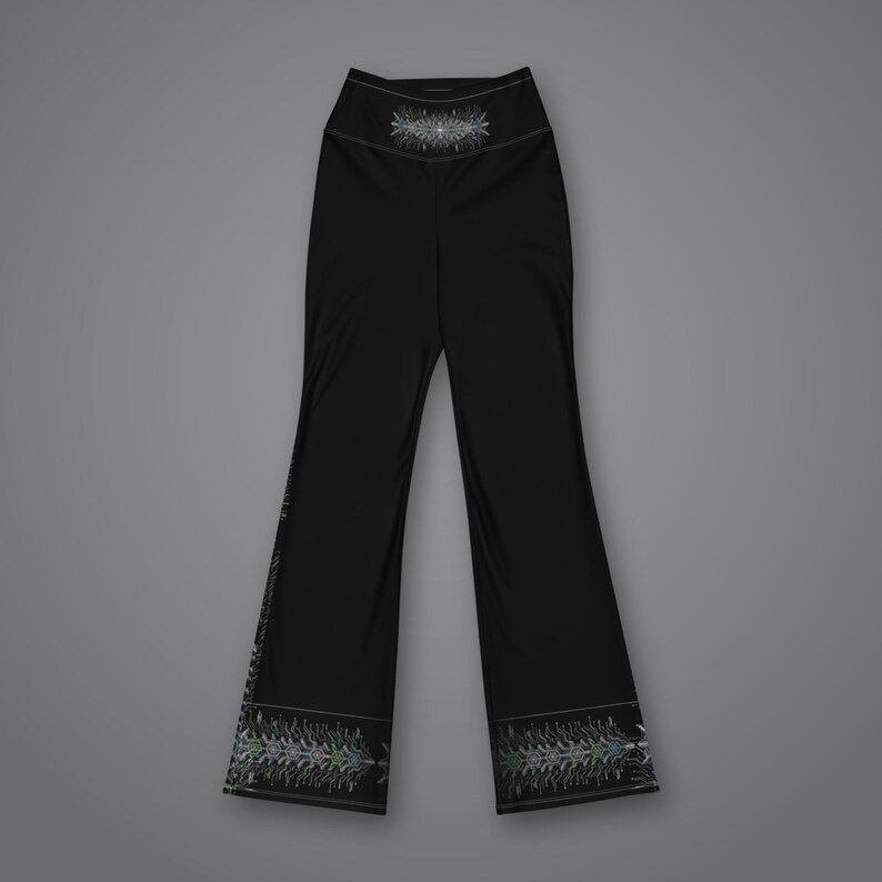 Pu&ograve; includere: Pantaloni neri a vita alta con gamba svasata, caratterizzati da un dettagliato motivo geometrico simmetrico bianco e grigio centrato sulla vita e lungo l'orlo inferiore di ogni gamba, in netto contrasto con il tessuto nero.