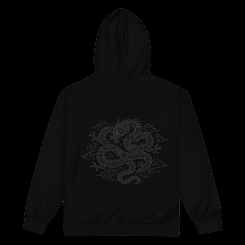 Puede incluir: Una sudadera con capucha negra que presenta un gr&aacute;fico de drag&oacute;n bordado en gris oscuro en la parte posterior. El drag&oacute;n aparece en posici&oacute;n enroscada rodeado de nubes estilizadas, con peque&ntilde;os detalles rojos en los ojos.