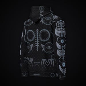 Puede incluir: Una sudadera con capucha negra que presenta un patr&oacute;n integral de dise&ntilde;os gr&aacute;ficos en blanco y azul claro. El estampado incluye motivos de ojos circulares, s&iacute;mbolos alados y una estructura de columna vertebral sobre un fondo de rejilla.
