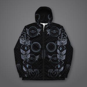 May include: A black zip-up hooded jacket featuring a repeating pattern of grey winged eyes, circular geometric motifs, and a subtle diamond grid texture. The garment includes a full-length front zipper, long sleeves, and a hood with a matching print.