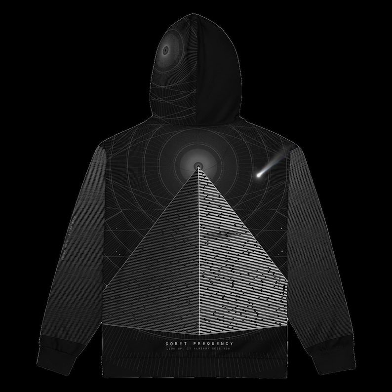 May include: A black hoodie featuring a graphic of a pyramid with horizontal line patterns. Above the pyramid is a circular design and a comet. The text COMET FREQUENCY LOOK UP AT LEAST NEAR YOU is printed at the bottom of the pyramid graphic.