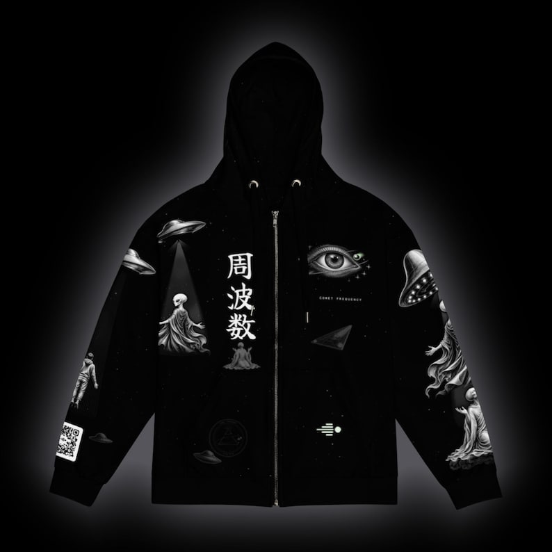May include: A black zip-up hoodie featuring white graphic prints of flying saucers, extraterrestrial figures, a large human eye, and Japanese characters that read 周波数. The design includes a QR code on the sleeve and small geometric symbols.