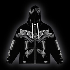 May include: A black zip-up hoodie featuring a white graphic print of large feathered wings across the chest and hood. The design includes symmetrical wing patterns on the sleeves and torso, with white drawstrings at the neck and a full-length zipper.