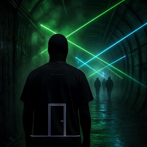 K&ouml;nnte beinhalten: Ein schwarzes Kurzarm-T-Shirt mit einer minimalistischen wei&szlig;en Strichzeichnung einer geschlossenen T&uuml;r auf der R&uuml;ckseite. Das Shirt wird von einer Person mit schwarzer Sturmhaube getragen, die in einem dunklen, von gr&uuml;nen und blauen Lasern beleuchteten Tunnel steht.