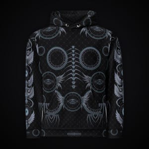 Puede incluir: Una sudadera negra con capucha y manga larga que presenta un patr&oacute;n repetitivo de motivos circulares grises, alas estilizadas y un gr&aacute;fico central vertical que recuerda a una columna vertebral sobre una textura de rombos.