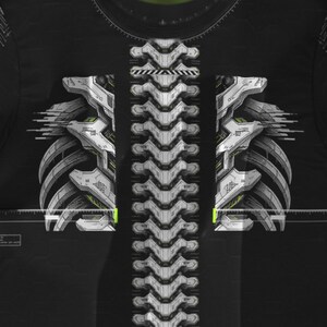May include: A black t-shirt featuring a white and gray graphic print of a mechanical spine and rib cage. The design includes technical line details, a horizontal measuring scale across the chest, and subtle yellow accents on a dark background.