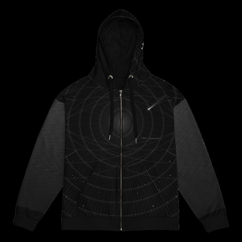 May include: A black zip-up hoodie featuring a white graphic print of concentric circular lines and a shooting star. The design includes a central dark sphere and small scattered dots. The sleeves have a subtle horizontal line pattern.