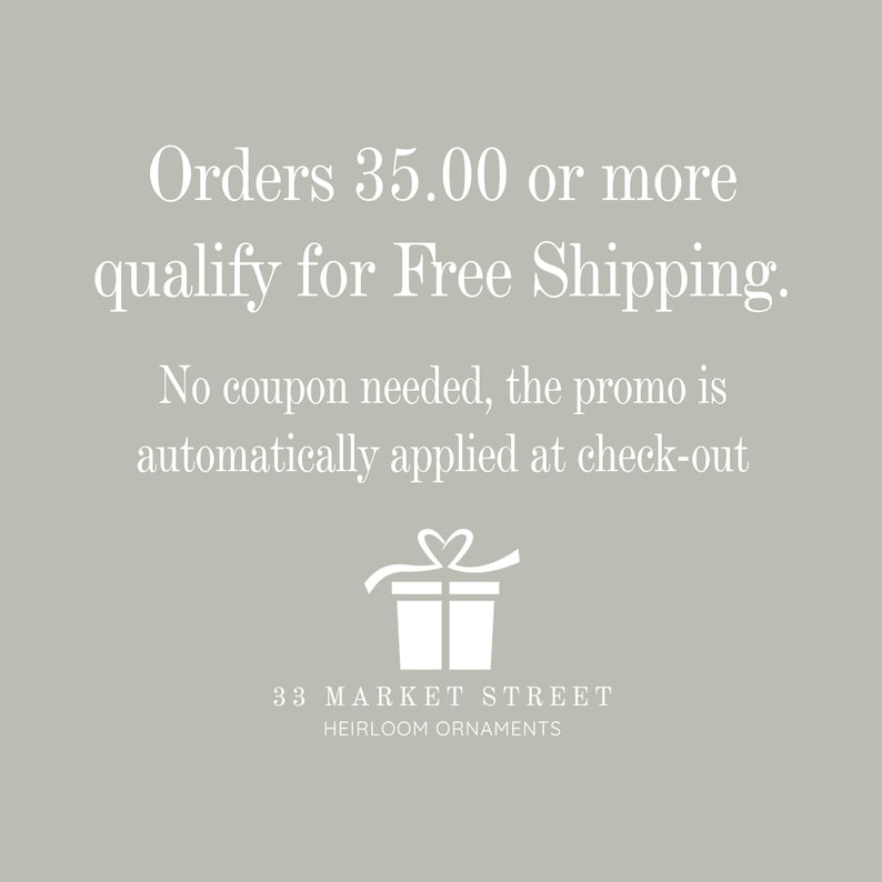 May include: White text on a grey background states "Orders &pound;35.00 or more qualify for Free Shipping. No coupon needed, the promo is automatically applied at check-out". A white gift box with a ribbon and heart is below the text. The text "33 MARKET STREET HEIRLOOM ORNAMENTS" is at the bottom of the image.