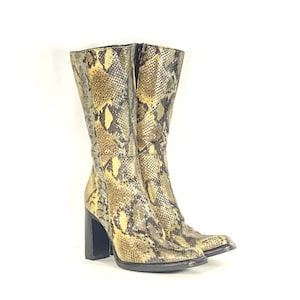 May include: A pair of brown and yellow snakeskin heeled boots with a block heel.