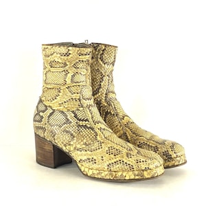 Puede incluir: Un par de botines de tobillo de piel de serpiente marrón y amarillo con tacón de bloque.