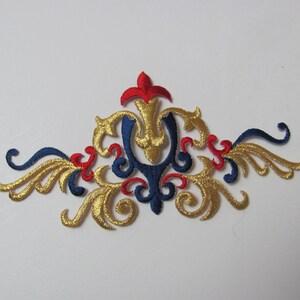 Könnte beinhalten: Goldene, blaue und rote gestickte Applikation mit einem floralen Design. Die Applikation ist perfekt, um Kleidung, Taschen oder Heimtextilien einen Hauch von Eleganz zu verleihen.
