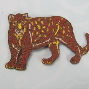 May include: A brown embroidered iron-on patch of a leopard with gold accents.