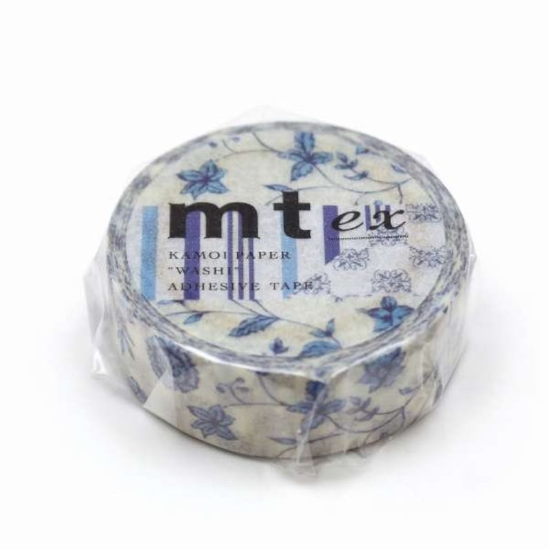 May include: A roll of decorative washi tape with a floral pattern in blue and cream. The tape is wrapped in clear plastic and features the text "mt" and "KAMOIPAPER WASHI ADHESIVE TAPE".