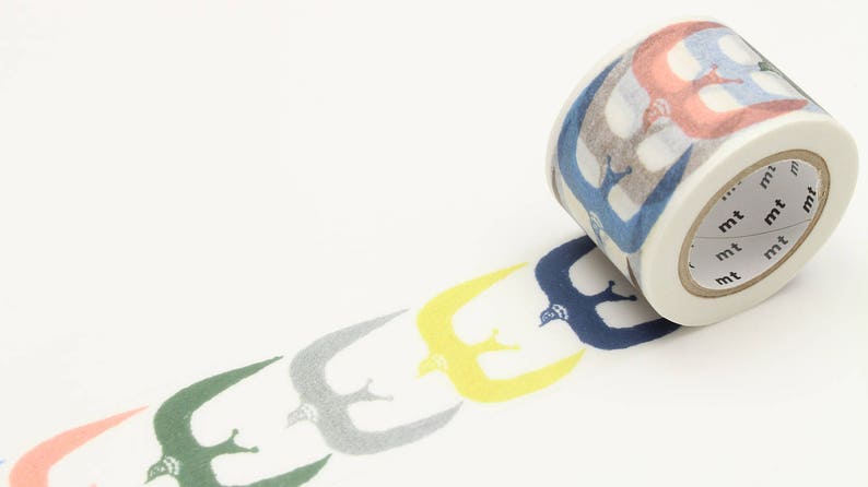 May include: A roll of washi tape with a repeating pattern of blue, yellow, green, and gray birds. The tape is unrolled and shows the pattern. The tape dispenser is white with the word "mt" repeated on it.