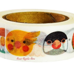 May include: A roll of decorative adhesive tape featuring a repeating pattern of colourful bird faces, including yellow, orange, and black designs. The text Sweet Supplies Store is printed in small red letters on the white background of the tape.