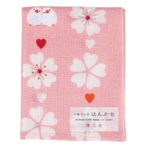 May include: Pink cotton hand towel with a white floral pattern and two white birds. The towel has a red heart and a red flower in the centre of each flower. The towel has the text "cotton100% Made in Japan" and "てぬぐい はんかち" in Japanese.