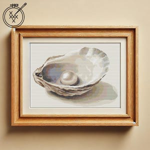 May include: A white pearl inside a beige oyster shell. The shell is open and the pearl is visible in the center.