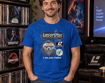 May include: A royal blue t-shirt featuring a graphic of a bearded face with a LaserDisc eye, a small LaserDisc character, the LaserDisc logo, and the text "LaserDisc The future of Home Entertainment" and "I am your Father" printed on the front.