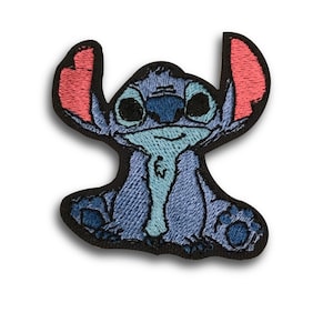 Peut inclure: Écusson brodé représentant le personnage de Stitch de Lilo & Stitch. L'écusson montre Stitch en bleu avec des oreilles roses et un bord noir. L'écusson est conçu pour être repassé ou cousu sur du tissu.