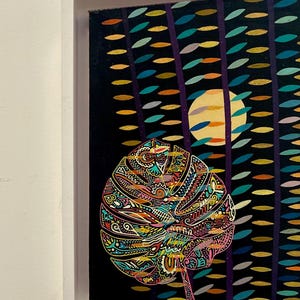 May include: A framed painting featuring a large, intricately detailed leaf in vibrant colors. The background is dark with vertical lines and colorful oval shapes, and a yellow circle. The artwork is framed in a white border.
