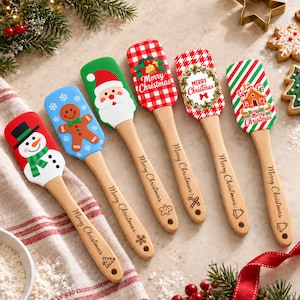 May include: Six silicone spatulas with wooden handles, each featuring festive holiday designs including a snowman, gingerbread man, Santa Claus, red plaid, wreath, and gingerbread house, with Merry Christmas text on handles.