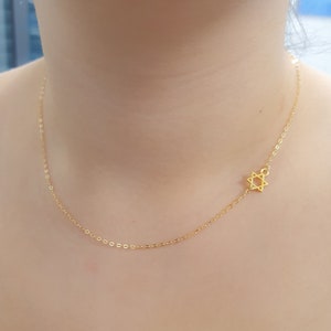 以下が含まれることがあります： 小さな繊細なダビデの星ペンダントが付いたゴールドチェーンネックレス