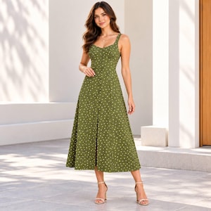 May include: A midi-length olive green dress featuring a white polka dot pattern, a sweetheart neckline, thin shoulder straps, and a vertical row of buttons running down the center front, paired with simple strappy sandals.