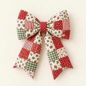 May include: A quilted fabric bow featuring a patchwork design of red, green, and white patterns including floral motifs, stripes, and polka dots. The center of the bow is a solid red fabric with white polka dots, and the ends are pointed.
