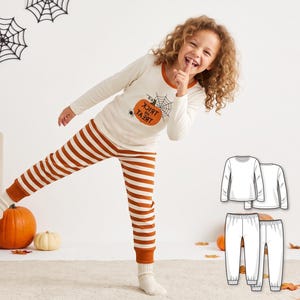May include: A long-sleeve cream-colored shirt with an orange pumpkin graphic and the text "TRICK OR TREAT" paired with orange and white striped pants featuring ribbed cuffs. Includes a technical line drawing of the shirt and pants.