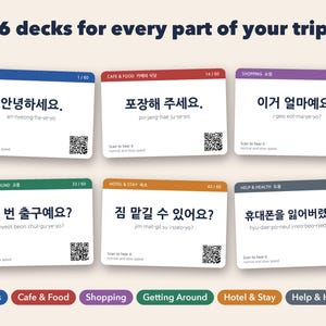 May include: Six rectangular flashcards with rounded corners, each featuring a different color header, Korean phrases with romanization, and a QR code. The text reads 6 decks for every part of your trip, Basics, Cafe & Food, Shopping, Getting Around, Hotel & Stay, and Help & Health.