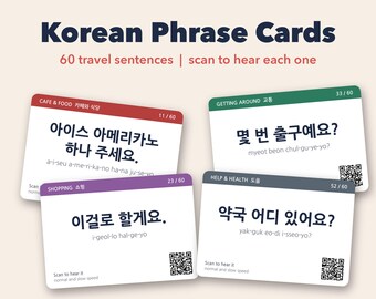 May include: A set of Korean Phrase Cards featuring 60 travel sentences. Four rectangular cards are displayed, each with a colored header, Korean text, romanization, and a QR code. The headers are labeled Cafe & Food, Getting Around, Shopping, and Help & Health.