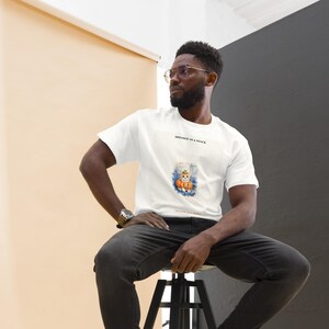 K&ouml;nnte beinhalten: Ein wei&szlig;es Kurzarm-T-Shirt mit einer Grafik einer Katze, die einen K&uuml;rbishut tr&auml;gt und in einem K&uuml;rbis sitzt. Der Text &uuml;ber der Grafik lautet DRESSED AS A SNACK und der Text unter der Grafik lautet ONE CUTE BUT SQUASHY.