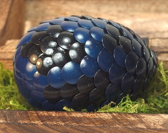 Egguf de dragon bleu avec des taches noires