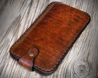 May include: A brown leather phone case with a stitched edge and a flap closure secured with a metal button.