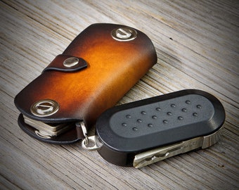 Könnte beinhalten: Ein brauner Leder-Schlüsselanhänger mit einem schwarzen und silbernen Multitool.