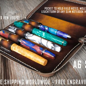 Puede incluir: Un estuche para bol&iacute;grafos de cuero marr&oacute;n con cierre de cremallera y cinco bucles para bol&iacute;grafos. El estuche est&aacute; abierto y tiene varios bol&iacute;grafos dentro. El estuche est&aacute; etiquetado con "A6 SIZE" y "FREE SHIPPING WORLDWIDE - FREE ENGRAVINGS".