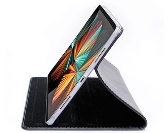 May include: A black leather tablet case with a blue stitching detail. The case is folded to create a stand for the tablet. A tablet with a colorful abstract design is in the case.