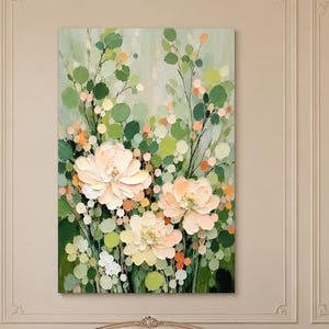 Puede incluir: Un cuadro rectangular vertical sobre lienzo que presenta tres grandes flores de color melocotón pálido rodeadas por un denso arreglo de follaje circular verde y claro y tallos finos sobre un fondo verde claro suave.