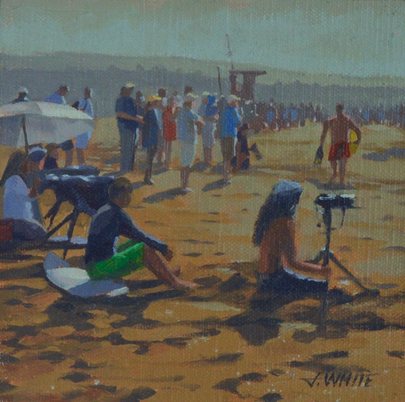 May include: A painting of a beach scene with people standing and sitting on the sand. There is a lifeguard stand in the background and a person holding a camera on a tripod. The painting is signed "J. White".