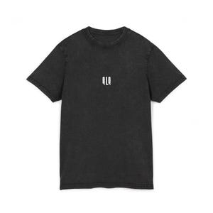 Puede incluir: Una camiseta de manga corta en color gris carbón con cuello redondo. El tejido tiene una textura lavada y desgastada. Centrado en el pecho hay un pequeño gráfico blanco con el texto estilizado QLQ en una disposición vertical sin remates.