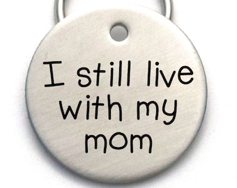 May include: Silver round key chain tag with the text "I still live with my mom" engraved on it.