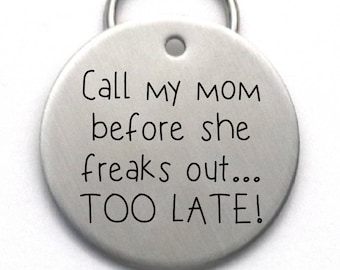 May include: Silver dog tag with the text "Call my mom before she freaks out... TOO LATE!"