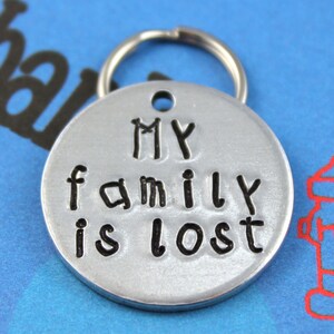 May include: Silver metal pet tag with a black inscription that reads "My family is lost".