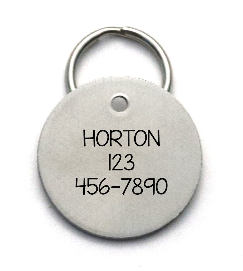 Pu&ograve; includere: Un'etichetta rotonda in argento per animali domestici con un portachiavi. L'etichetta &egrave; incisa con il nome "HORTON" e il numero di telefono "456-7890".