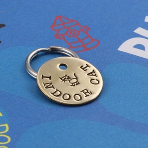 Puede incluir: Llavero de metal con una silueta de gato y el texto "Indoor Cat" grabado.